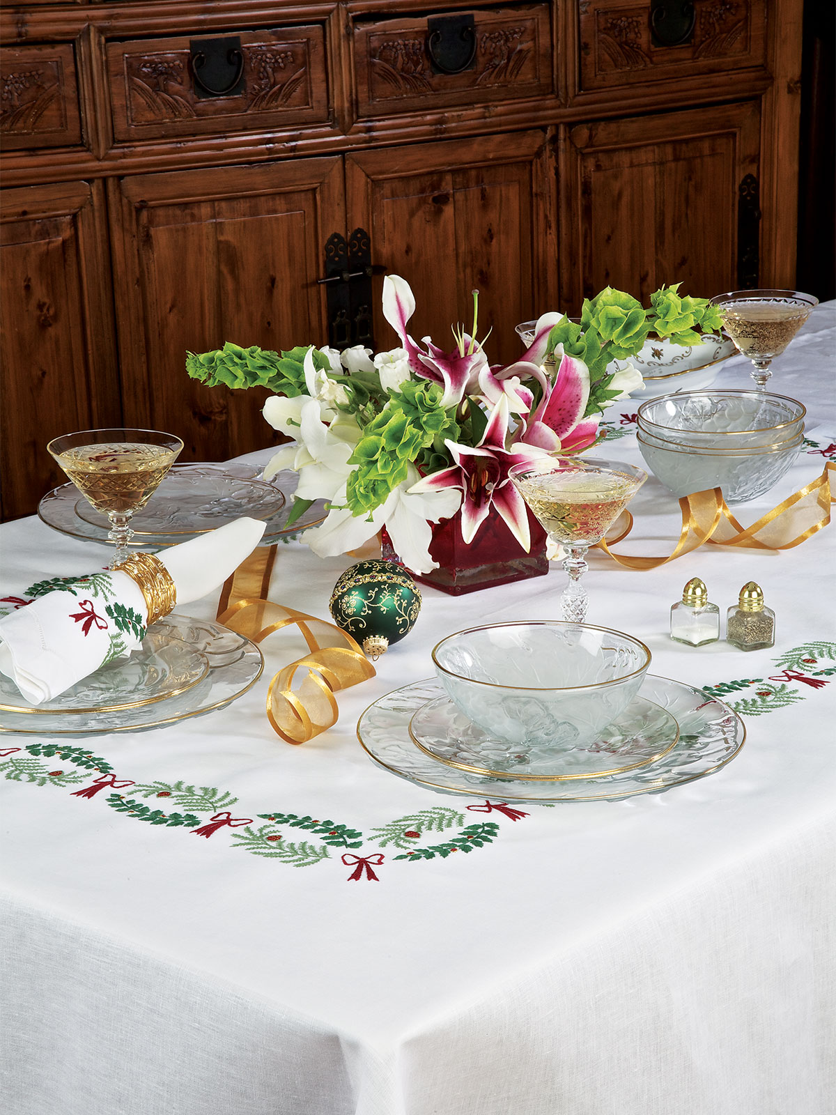 Image of the Holly Days holiday table linens featuring holly embroidery and rich seasonal