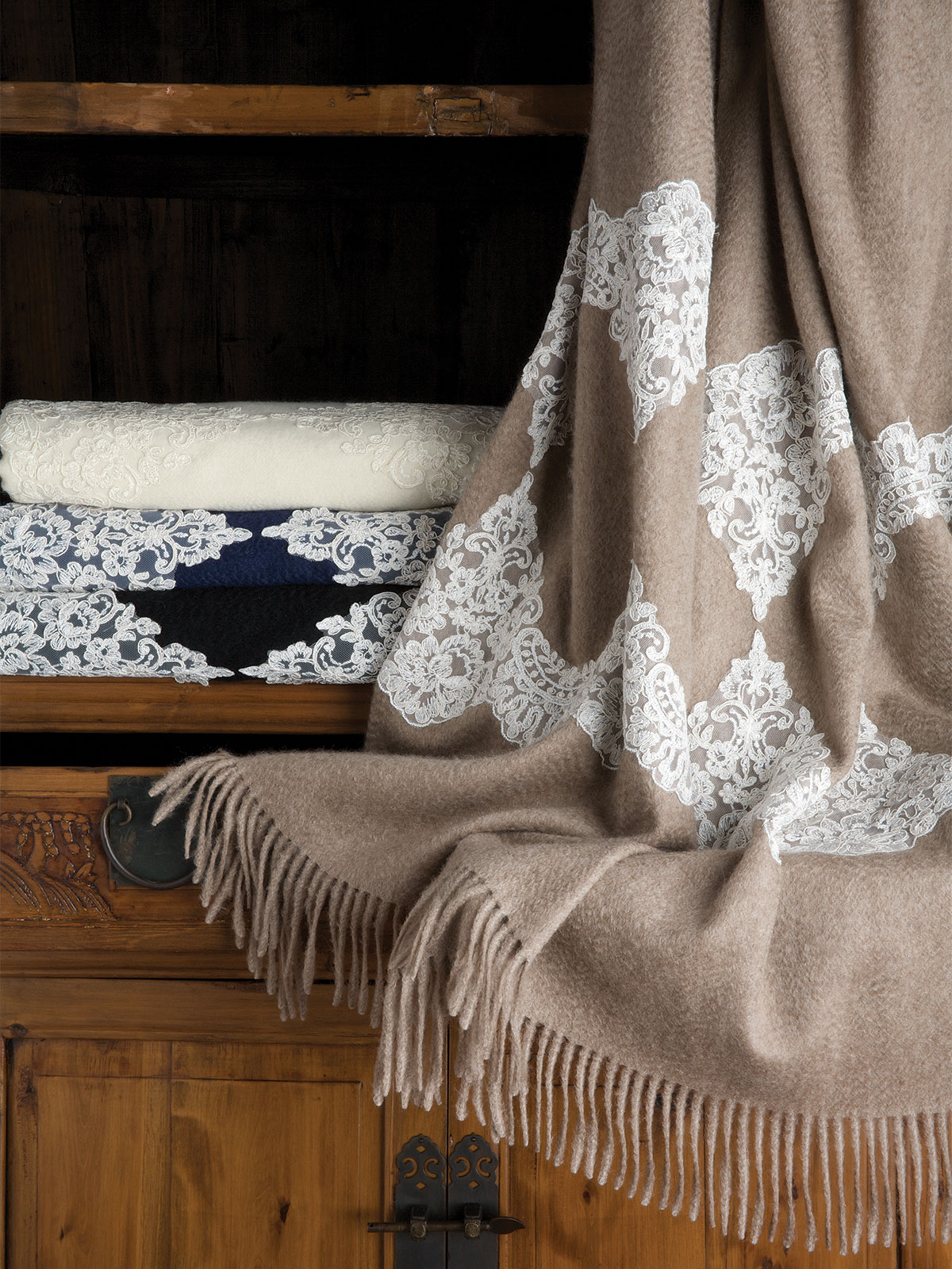 Image of the Bagatelle cashmere throw styled at the foot of a bed, showcasing rich texture and timeless elegance